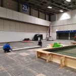 Handwerker auf der Messe beim Teppich verlegen 2018